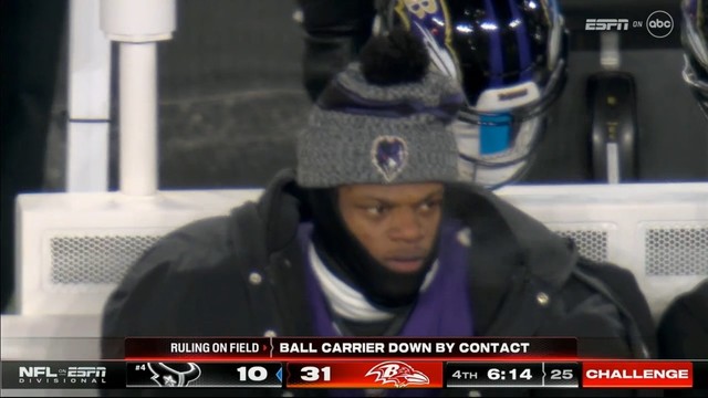 A person wearing a beanie with a sports team's logo (Lamar Jackson) is sitting, with the text overlay indicating a ruling on the field and displaying the score and time left in a football game.