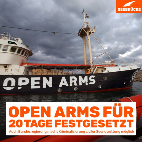 Foto der GOLFO AZZURO* mit großem weißer Schriftzug OPEN ARMS auf dem dunkelblauen Rumpf von einem Beiboot aus.
In einem weißen Kasten steht:
OPEN ARMS FÜR
20 TAGE FESTGESETZT
Auch Bundesregierung macht Kriminalisierung ziviler Seenotrettung möglich
In der rechten oberen Ecke ist das Seebrücke-Logo in weiß auf orange.

*) Die Golfo Azzurro war von Dezember 2016 bis Herbst 2017 von Proactiva Open Arms für Rettungseinsätze im zentralen Med gechartert.
