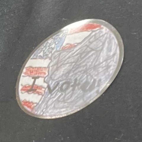 Circular sticker with drawn American flag and Old Man of the Mountain and the words, "I voted!"