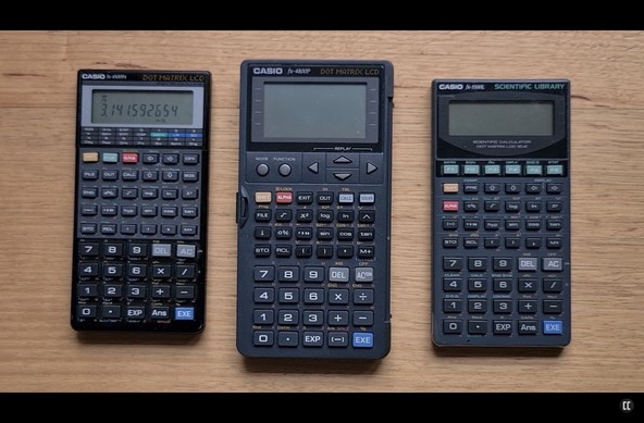 Three Casio scientific calculators laid out on a wooden surface.