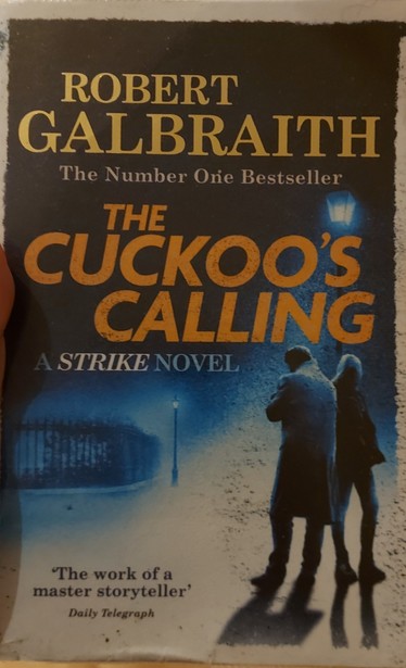 A high contrast picture of two figures standing silhouetted to the right, in dark blue to white. The title is printed in yellow.