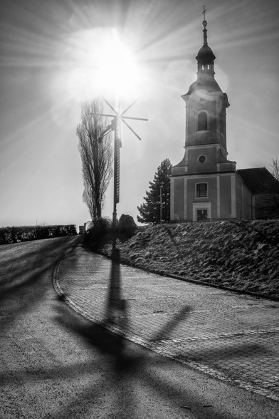 A church and a Klapotetz (a wind mill that makes noise to drive birds away from the vineyard) against the sun photographed 
Eine Kirche und ein Klapotetz (ein Windrad, die Lärm macht, um Vögel vom Weinberg zu vertreiben) im Gegenlicht fotografiert
