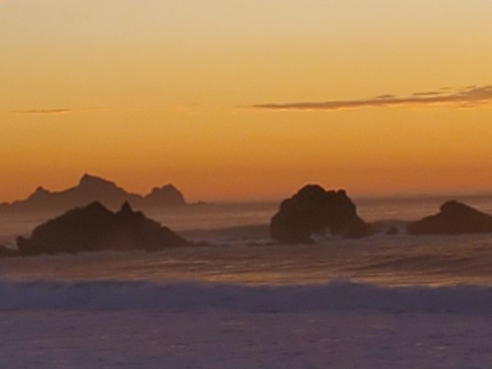 This one also looks like something out of a matte painting for a science fiction landscape.  Pale orange afterglow and rocks in the ocean in the foreground.