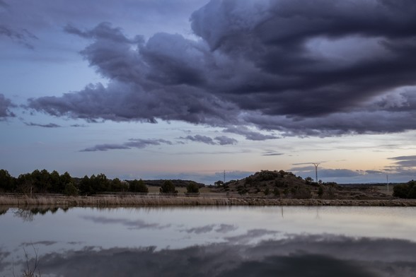 Foto de un paisaje al final del atardecer (en la hora azul) en el cual se ve una gran nube.

Photo of a landscape at the end of sunset (at blue hour) with a big cloud.