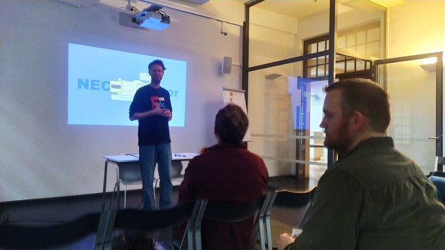 Yorik stood in front of a projection screen talking to a group. 