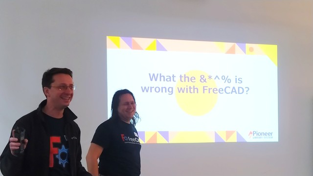 FreeCAD developers stood in front of a screen that says "What the $%*- is wrong with FreeCAD"