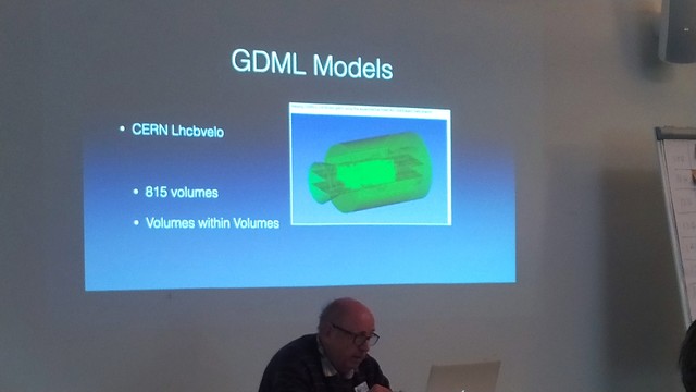 Keith sits in front of a projector. The slide is titled "GDML Models" and shows a green 3D model of a chamber with a nozzle. 