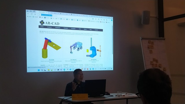 Dr Aik-Siong Koh in front of a projector showing some of his previous projects. Includes a version of a software called "freeCAD" that predates FreeCAD by two years. 