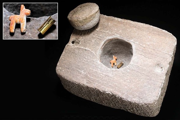 Piedra cuadrada con agujero circular y tapa de la misma forma. En su interior, una figura y una lámina metálica.