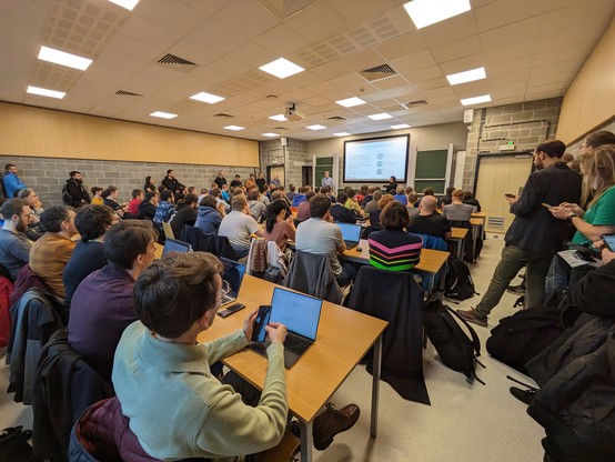 Picture of the audience of the said devroom, roughly 80 persons