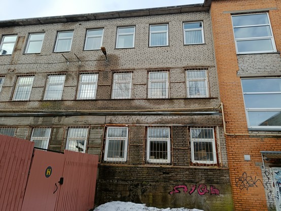The windows of the concrete building have bars