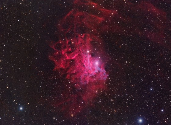 Flaming Star Nebula:
Background is black with stars dotted throughout.

Filling much of the center area of the image is red nebulosity, which extends towards the upper edge and with fainter nebulosity to the upper right corner.

There are undulations of brighter and fainter areas of red nebulosity including some dark areas with no nebulosity.

At the core center of the image are some ribbon streams of light purple nebulosity. These seem to originate from a particularly bright star at the center of the image.
