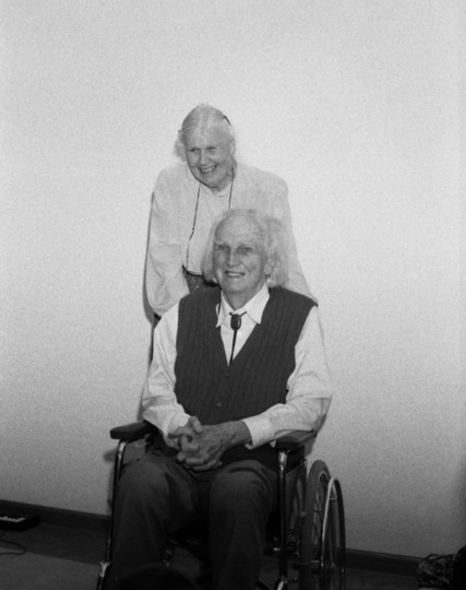 Elise Boulding smiling standing behind her love and companion and partner.

Kenneth Boulding in a wheelchair with his love and companion and partner just behind.

Two brilliant academics that tirelessly fought for peace in their own separate fields.