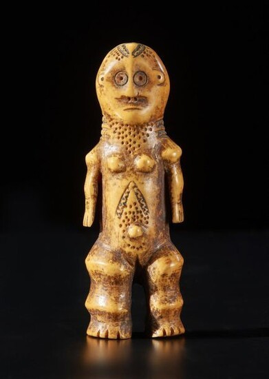 Carved ivory sculpture of a standing female figure. She has carved round eyes, nostrils, ears and possibly hair in the form of dots. A thin line serves as the mouth. She has small, thin arms and big, chunky legs. Her breasts are small and perky, her navel protruding. Her labia are carved so a slit is well visible. Her body is decorated with dots that could be decorative scars or cosmetics.