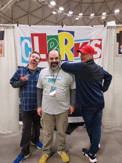 Bryan O'Halloran doing a "this fucking guy" pose while Jeff Anderson shows his ass and leans on my shoulder at Twin Cities Con 2023. I'm wearing my Minnesota Con 2023 shirt and having the time of my life.
