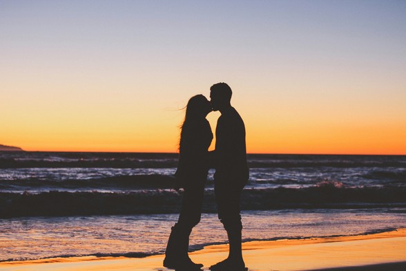  Photo of a couple kissing at the seashore in silhouette 