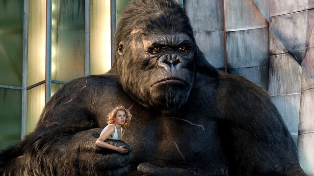 Der riesige und grimmig dreinblickende King Kong hält die blonde Naomi Watts in weißem Kleid in seiner rechten Hand.