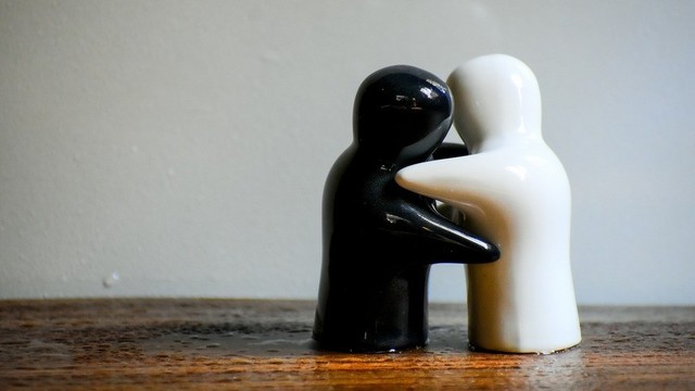 Small black and white figurines hugging.