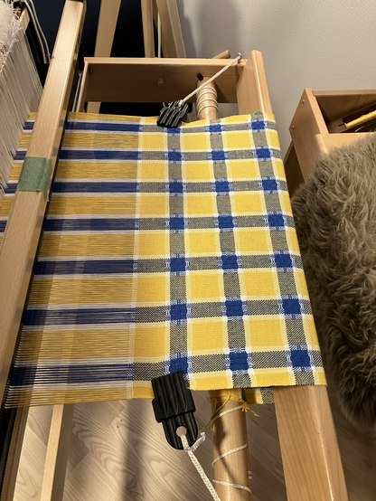 Yellow and blue stripe huck lace teatowel in progress on a hand loom