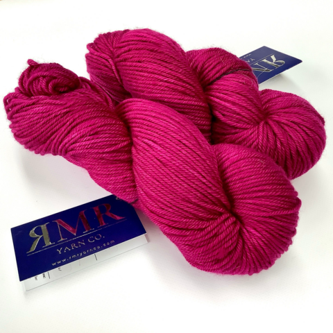 2 skeins of deep pink yarn shown on a white background.
