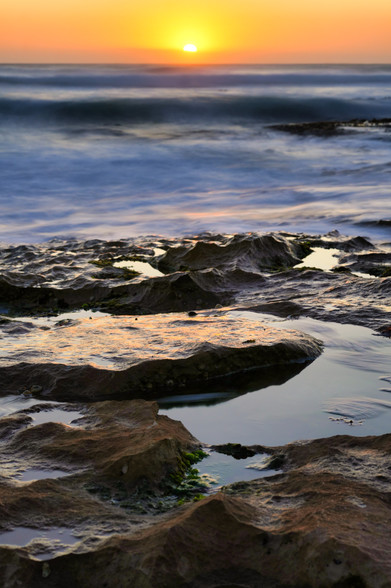 A sunset in the dusky sky with layers of sky, ocean and rocky water holes in Pirate Bay Mornington Peninsula Melbourne 