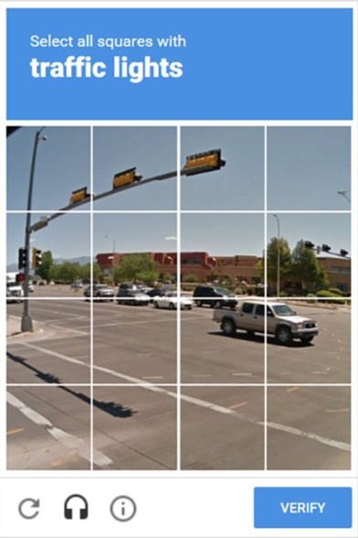 A screenshot of a typical Captcha™. This one has a photograph of an intersection. The photo is divided into 16 squares (4×4). The instructions ask the user to select all squares that contain a traffic light. At the bottom is a button labelled "Verify".