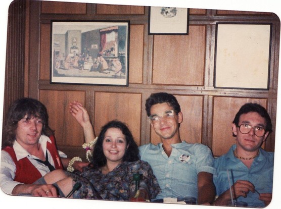 Photo from 1970s showing Geoff Downes, Tina Charles, Bruce Woolley and Trevor Horn seated against a brown wood-paneled wall. Geoff, Tina and Bruce are smiling. Trevor looks like he'd rather be somewhere else LOL.