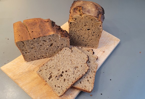 Farbfoto: Dasselbe Brot, teilweise aufgeschnitten, mit etwas unregelmäßiger Porung in der unteren Mitte. 