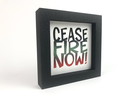 A framed relief print that says “Ceasefire Now!”.