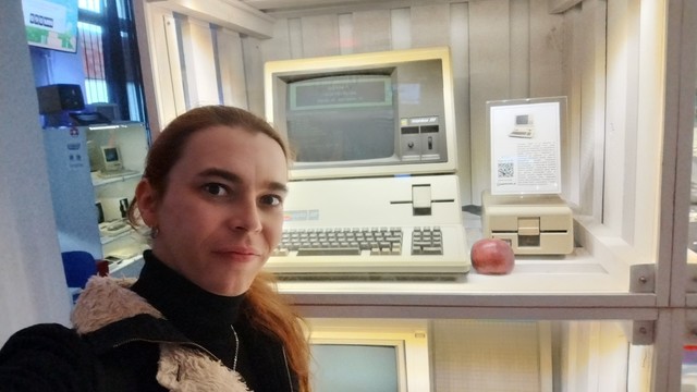 A person standing in front of museal exhibit of Apple 3 computer.