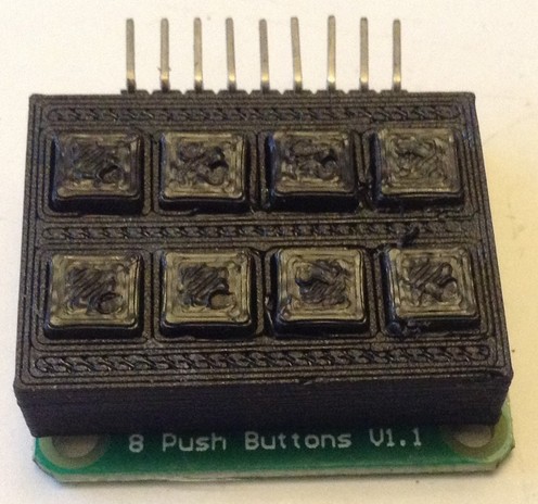 Another photo of a 3D print for a 2x4 matrix of buttons.  Shown sitting on top of the PCB of buttons it is designed for.  This time the buttons stick out slightly in a much more useful way and the case is of sufficient height to actually sit nicely on the PCB.