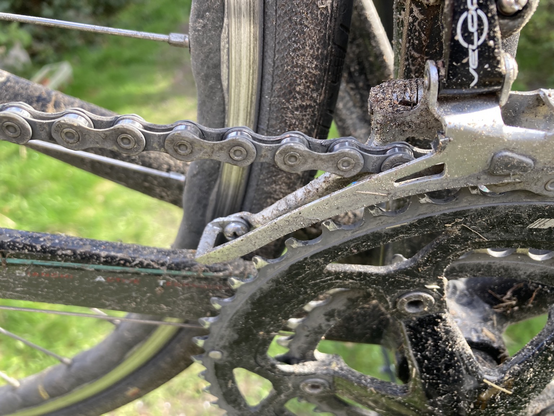 Close-up of the mud caked front derailleur of the bike