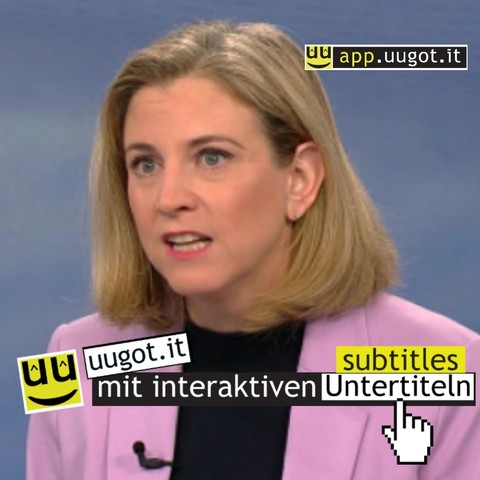 Das Bild zeigt eine Beate Meinl-Reisinger, die ein Interview gibt oder an einer Diskussion teilnimmt. Im Vordergrund wird die Funktionalität der interaktiven Untertitel mit "click2translate" stilisiert dargestellt, wobei auf ein Wort in den Untertiteln geklickt wird, um eine Übersetzung anzuzeigen. Diese Funktionalität erleichtert es, dem Inhalt zu folgen, wenn man die Sprache noch nicht flüssig beherrscht. Sie ist konzipiert für mediale Teilhabe, die Integration von Zuwanderern und das Erlernen der deutschen Sprache. Das Logo "app.uugot.it" ist im Bild integriert, und es wird darauf hingewiesen, dass Videos auf der Plattform app.uugot.it abgerufen werden können.