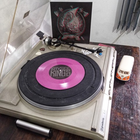 Vinil no toca discos e de fundo na foto capa do vinil miniatura de Kombi na foto 