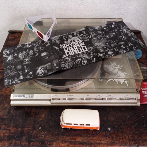 Encarte do vinil e óculos 3D miniatura de Kombi na foto 
