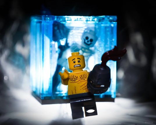 A LEGO minifigure being chased by a gelatinous cube with a skeleton inside
