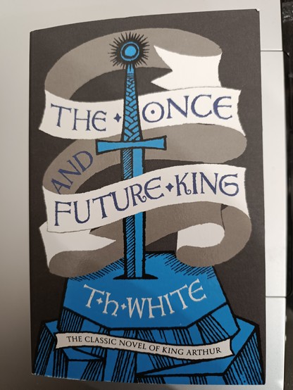 "The Once and Future King" cycle by T.H. White. The cover shows a blue sword in a stone, with the title wrapped in parchment around.