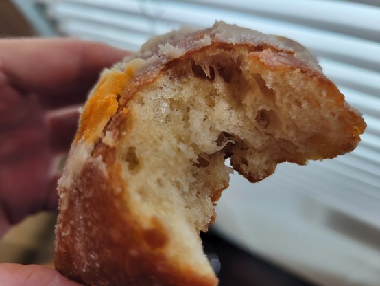 Traditional plain beignet, partially eaten, showing the interior of the pastry