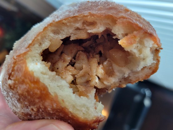Granny Smith Apple beignet, partially eaten, showing the filling which is sweetened with cinnamon-honey butter