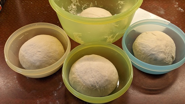 Drei kleine und eine große Tupperdose mit jeweils einem Teigbällchen drin.