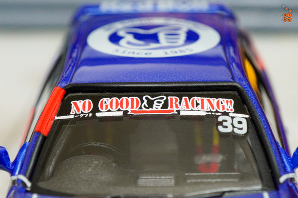 A close-up shot of Honda Civic Type-R EK9 No Good Racing Red Bull Livery by INNO64 in 1:64 scale with 1:64 figure on area 164
