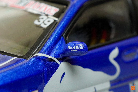 A close-up shot of Honda Civic Type-R EK9 No Good Racing Red Bull Livery by INNO64 in 1:64 scale with 1:64 figure on area 164