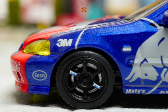 A close-up shot of Honda Civic Type-R EK9 No Good Racing Red Bull Livery by INNO64 in 1:64 scale with 1:64 figure on area 164