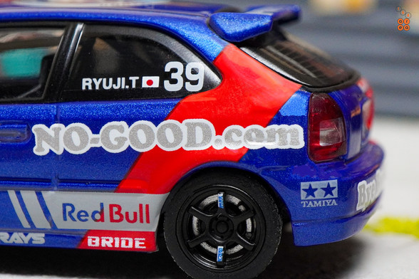 A close-up shot of Honda Civic Type-R EK9 No Good Racing Red Bull Livery by INNO64 in 1:64 scale with 1:64 figure on area 164
