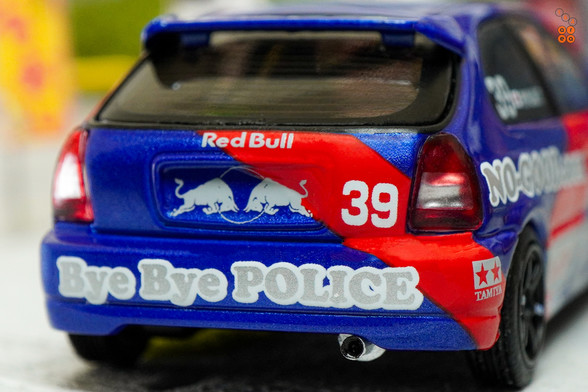 A close-up shot of Honda Civic Type-R EK9 No Good Racing Red Bull Livery by INNO64 in 1:64 scale with 1:64 figure on area 164