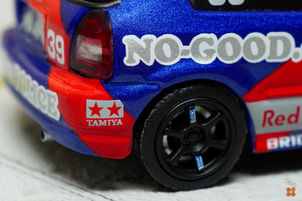 A close-up shot of Honda Civic Type-R EK9 No Good Racing Red Bull Livery by INNO64 in 1:64 scale with 1:64 figure on area 164