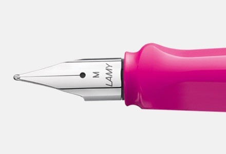 Closeup of the front end and nib of a pink LAMY Safari ballpoint pen.