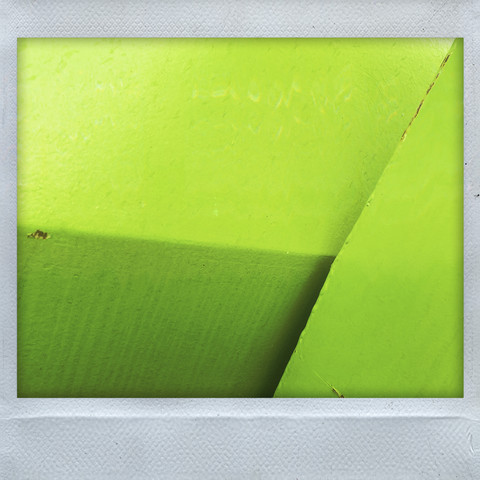 Abstract blocks of colour formed by the juxtaposition of the local recycling bins. Each metal bin is painted in a primary colour. Generally unattractive, this perspective brings a splash of colour from otherwise boring urban furniture. Here: green against green, light and shade providing the contrast. 