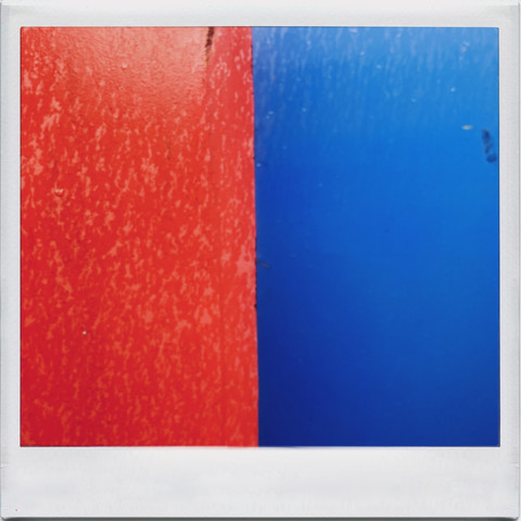 Abstract blocks of colour formed by the juxtaposition of the local recycling bins. Each metal bin is painted in a primary colour. Generally unattractive, this perspective brings a splash of colour from otherwise boring urban furniture. Here: blue against red, but a different blue and a different red. You had to be there. 