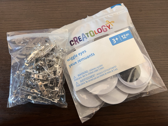 A bag of pin backs and a bag of googly eyes (aka wiggle eyes).